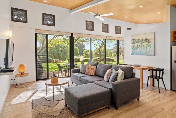 Relax in the open-plan living and dining space, where sunlight pours through large windows overlooking the estate.