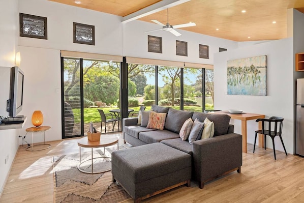 Relax in the open-plan living and dining space, where sunlight pours through large windows overlooking the estate.
