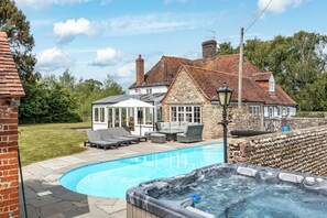 The hot tub and pool area in front of the main house and annexe.