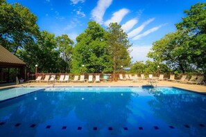A serene outdoor pool surrounded by lush greenery and peaceful views. Outdoor pool seasonal memorial day to labor day