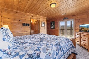 Bedroom 3 with king bed, deck access, TV, and private ensuite