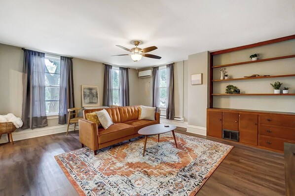 Thoughtful design and cozy accents create the perfect space to unwind and make yourself at home in this living room. Large windows let in lots of natural light. 