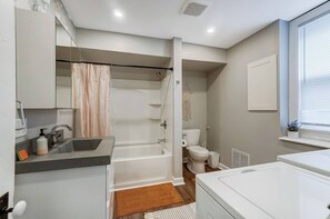 Large bathroom with bathtub/shower combo, also has in home laundry. 