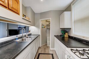 Cook up a storm in this charming, fully equipped galley kitchen, complete with gas stove and oven. Perfect for preparing meals in a compact, yet functional space. 
