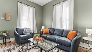 A warm and inviting living room setup. A large couch paired with a side chair creates a comfortable space for lounging. 