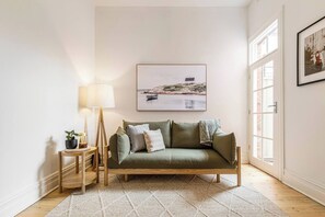 Unwind on the olive sofa, surrounded by warm timber tones and soothing artwork, while enjoying your favourite shows in the living room.
