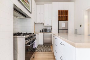 Cook with ease in the well-equipped kitchen, featuring an oven, dishwasher, and Nespresso machine, while prepping meals on the spacious island.