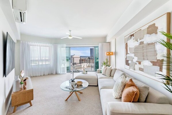 Settle into the open-plan living area, featuring an L-shaped sofa, a smart TV with Netflix, split-system air conditioning and a ceiling fan for year-round comfort.