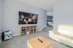 Entertainment bonus room featuring a 85-inch TV and comfy leather sofas