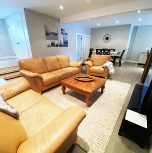 Spacious living room with oversized leather couch, loveseat & armchair, SmartTV
