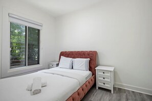 Bedroom 1- Charming bedroom with a plush pink tufted headboard