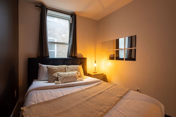 Bedroom 3: Cozy and modern with warm lighting and layered pillows