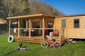 The lovely terrace provides an idyllic space for family fun and relaxation, complemented by outdoor seating and easy access to the green surroundings.
