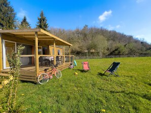 The outdoor area beckons with its spacious lawn, perfect for family fun and relaxation, where children can play and parents can unwind under the sun.