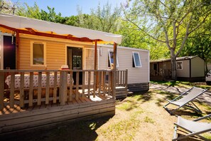 Stay in a cosy mobile home with a wooden terrace, perfect for outdoor relaxation.