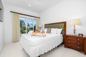 A spacious, clean, modern bedroom with a comfortable king-size bed.
