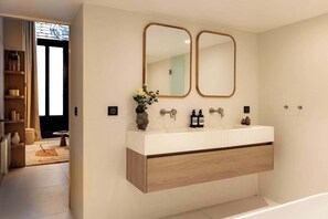 Salle de bain avec double vasque, baignoire, douche, et toilette