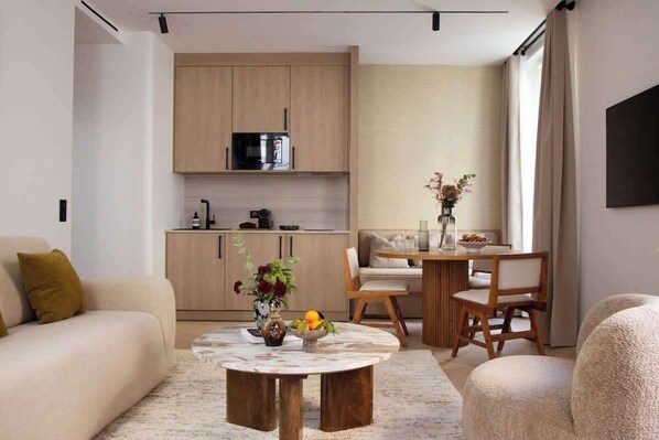 Une belle pièce à vivre dotée d'un canapé convertible, une table d'appoint, une table à manger et une TV. Cuisine ouverte sur la pièce à vivre 