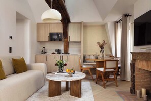 Une pièce à vivre dotée d'un canapé convertible, une TV, une table d'appoint et une table à manger pour 6 personnes. 