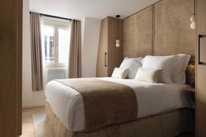  Une chambre parée d’un lit Queen Size, d'une penderie et d'une TV.
