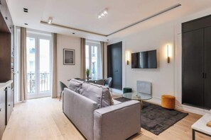 Une spacieuse pièce à vivre dotée d’un canapé-lit, meublé avec goût et invitant à la détente et à la convivialité.