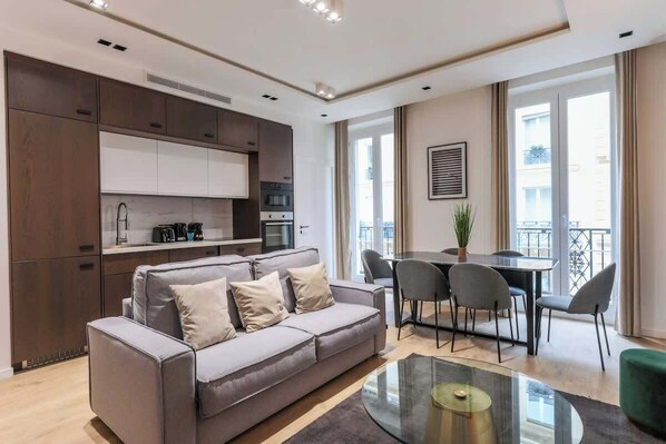 Une spacieuse pièce à vivre dotée d’un canapé-lit, meublé avec goût et invitant à la détente et à la convivialité.
