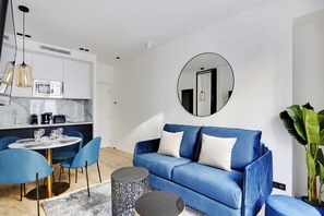 Un salon spacieux et lumineux avec un canapé-lit et une table à manger élégante pratique pour savourer les repas dans un cadre convivial.