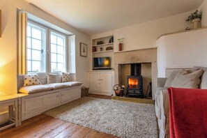 Cosy living room with window seat and wood burning fire