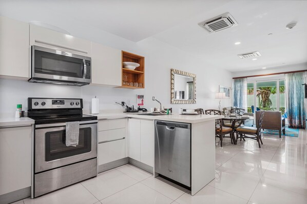 Fully equipped kitchen with stainless steel appliances and sleek countertops - Cook with ease in this stylish space featuring a stove, microwave, and dishwasher - Open concept design connects the kitchen to the living area, perfect for entertaining