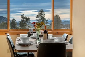 The dining room looks over a panoramic long-range interrupted mountain view