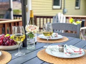 Stylish close-up of an outdoor dining table set with modern dishware and cozy seating—perfect for al fresco dining, morning coffee, or evening drinks.