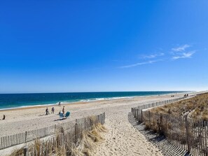Scenic view of the nearby beach, highlighting the pristine sand and clear blue waters just steps away.
