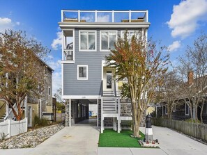 The stylish exterior of this newly renovated beach block home features ample parking and a clean, modern aesthetic.