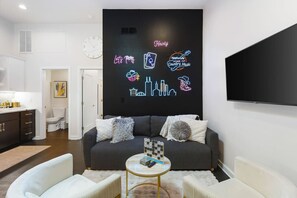 Comfortable living room with lots of natural light! Smart TV with all the apps you could want. The couch turns into a futon sofa. Unique neon lights and decor throughout the entire condo!