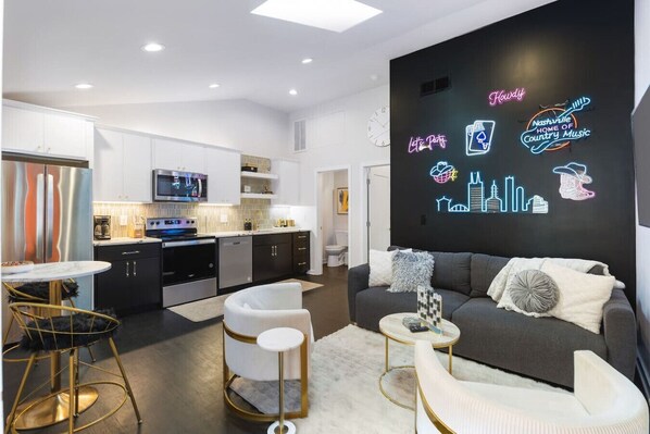 Comfortable living room with lots of natural light! Smart TV with all the apps you could want. The couch turns into a futon sofa. Unique neon lights and decor throughout the entire condo!
