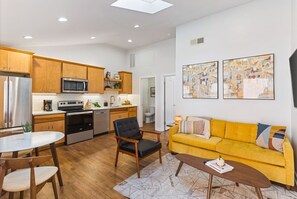 Comfortable living room with lots of natural light! Smart TV with all the apps you could want. The couch turns into a pullout sofa. Unique mid century modern decor throughout the entire condo!