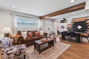 Comfortable living room with lots of natural light! Smart TV with all the apps you could want. The couch turns into a Queen sleeper sofa. Dining table and chairs. Unique wallpaper, patterns and decor throughout the entire condo!
