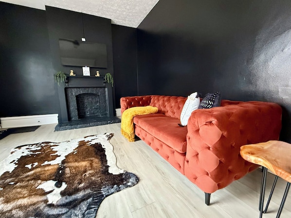 "& Unwind in style in our modern Jungle House living room in Columbus! Our vibrant orange tufted sofa, cozy yellow throw blanket, and chic cowhide rug create the perfect space to relax. & Our plants are looking forward to hosting you soon 🌿😀 Book your stay now and experience the perfect blend of comfort and elegance. #ModernLiving #ColumbusVacation #JungleHouseStay
