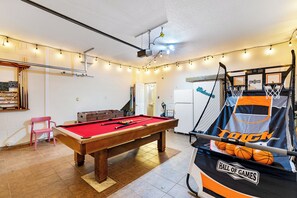 Featuring a pool table, basketball shootout, and festive lighting, this vibrant game room is perfect for nonstop fun with family and friends.