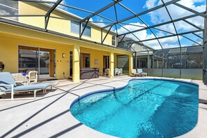 Beautiful pool deck with a covered lanai, perfect for outdoor dining and relaxation. Unwind in the hot tub for the ultimate vacation experience