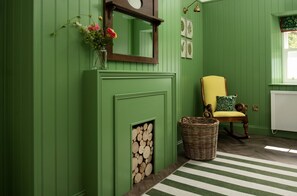 The Hayloft, Kailzie - welcoming entrance hall and boot room with accent chair and decorative fireplace
