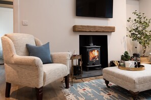 Coachman's Cottage - an armchair beside the log burner