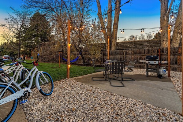 Backyard | String Lights, BBQ Grill, and Outdoor Dining Area | Cruiser bicycles available for your use!
