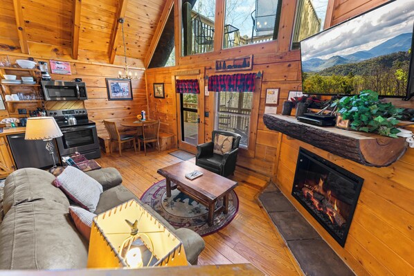 Living area with electric fireplace, TV, and cozy seating 