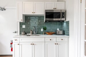 Charming kitchenette in Unit 2 with subway tile backsplash, located in the same room as the sitting area and dining table. Ideal for preparing light meals and snacks before heading to Stratford Festival theatres or exploring the Avon River. This kitchenet