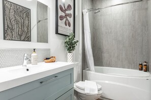 Modern bathroom in Unit 2 with subway tile and a relaxing tub, perfect for a soak after a full day at the Stratford Festival or exploring the Avon River. This elegant bathroom offers a touch of luxury for those seeking Stratford Festival accommodation in 