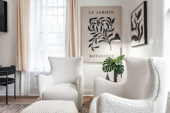 Spacious sitting room in Unit 2 with comfortable wingback chairs, a Smart TV, and a small dining area. Located in the same space as the kitchenette, this room is perfect for relaxing after a day at the Stratford Festival. Explore Stratford’s cultural offe