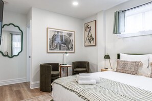 Comfortable queen bed in the main room of Unit 4, offering a cozy retreat within a single-room layout that includes a wet bar and sitting area. Perfect for couples or solo travelers attending the Stratford Festival or exploring downtown Stratford Ontario.