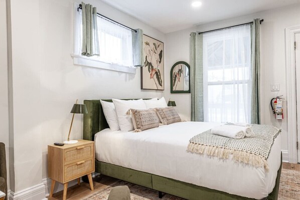 Comfortable queen bed in the main room of Unit 4, offering a cozy retreat within a single-room layout that includes a wet bar and sitting area. Perfect for couples or solo travelers attending the Stratford Festival or exploring downtown Stratford Ontario.