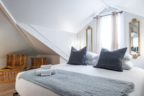 Loft-style bedroom in Unit 3 featuring two luxurious king beds and a spacious sitting area, all within the same open-concept room. This elegant space is perfect for families or groups visiting Stratford Ontario for the Stratford Festival. Relax in comfort
